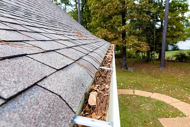 removing debris and leaves from the gutter