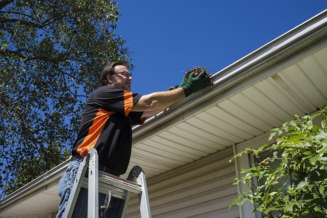 skilled laborer working on gutter repairs in Hadley